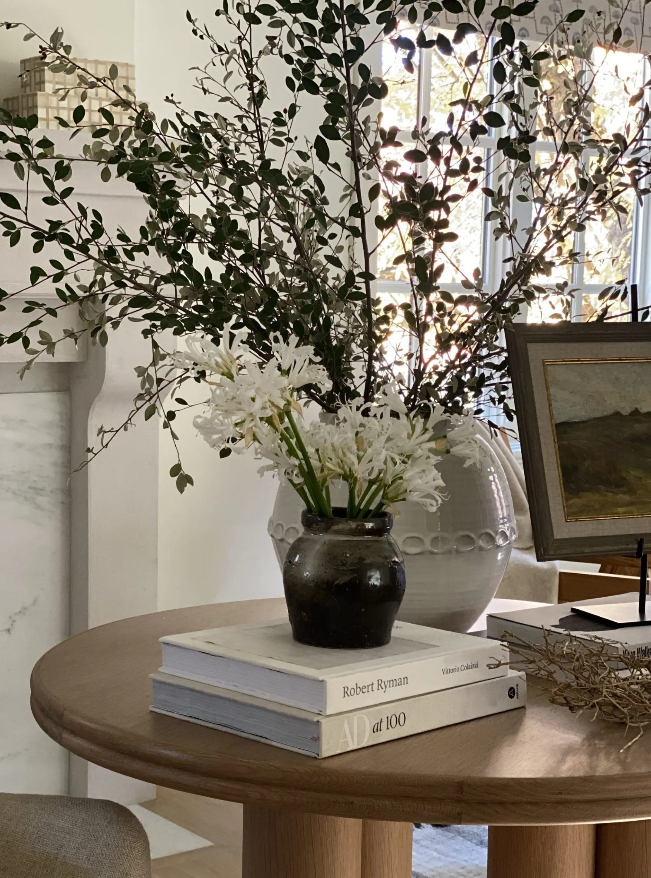 Oversized greeenry and flower arrangement on a table.