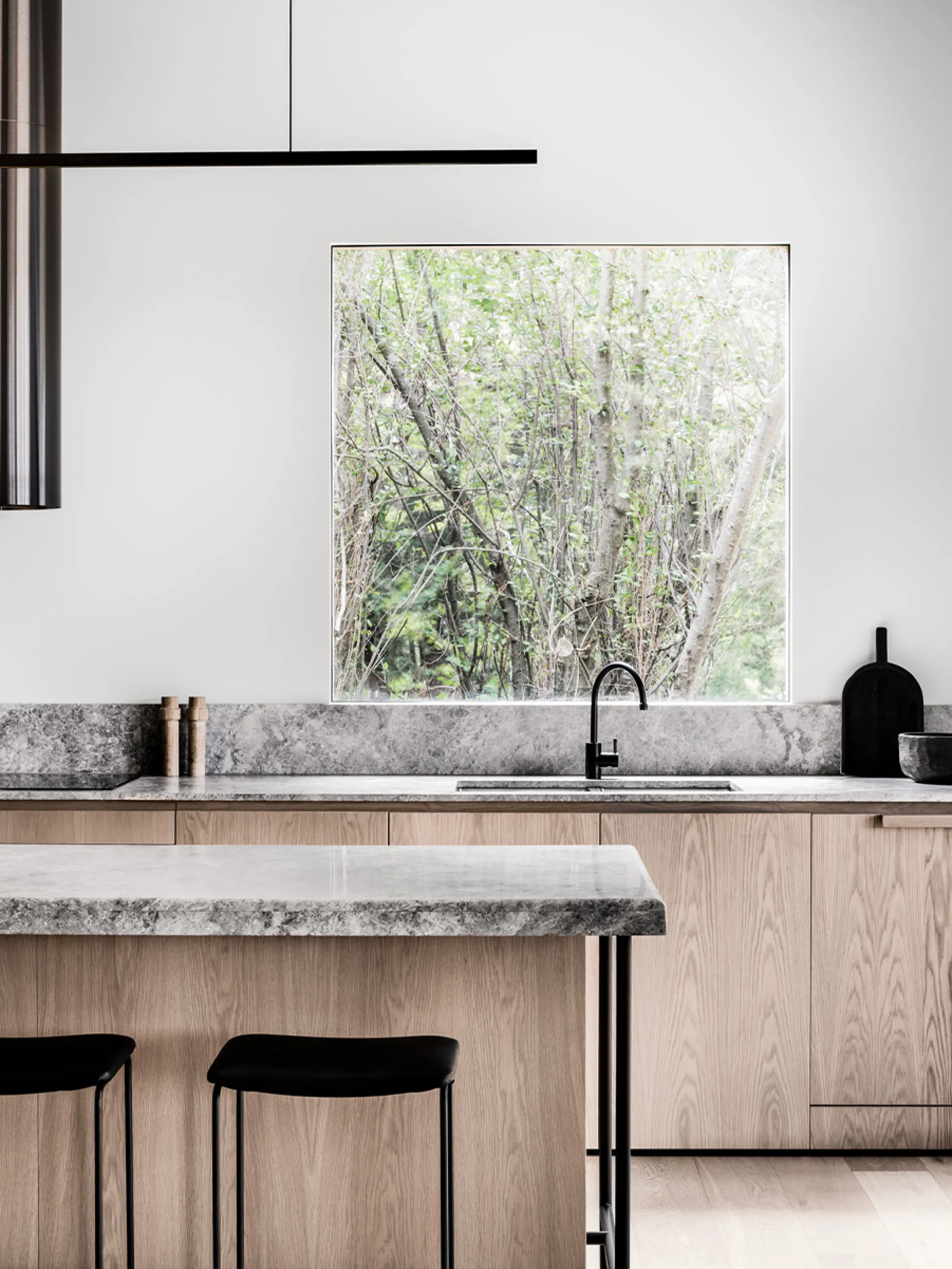 Minimalist kitchen with wood cabinets and stone countertops.