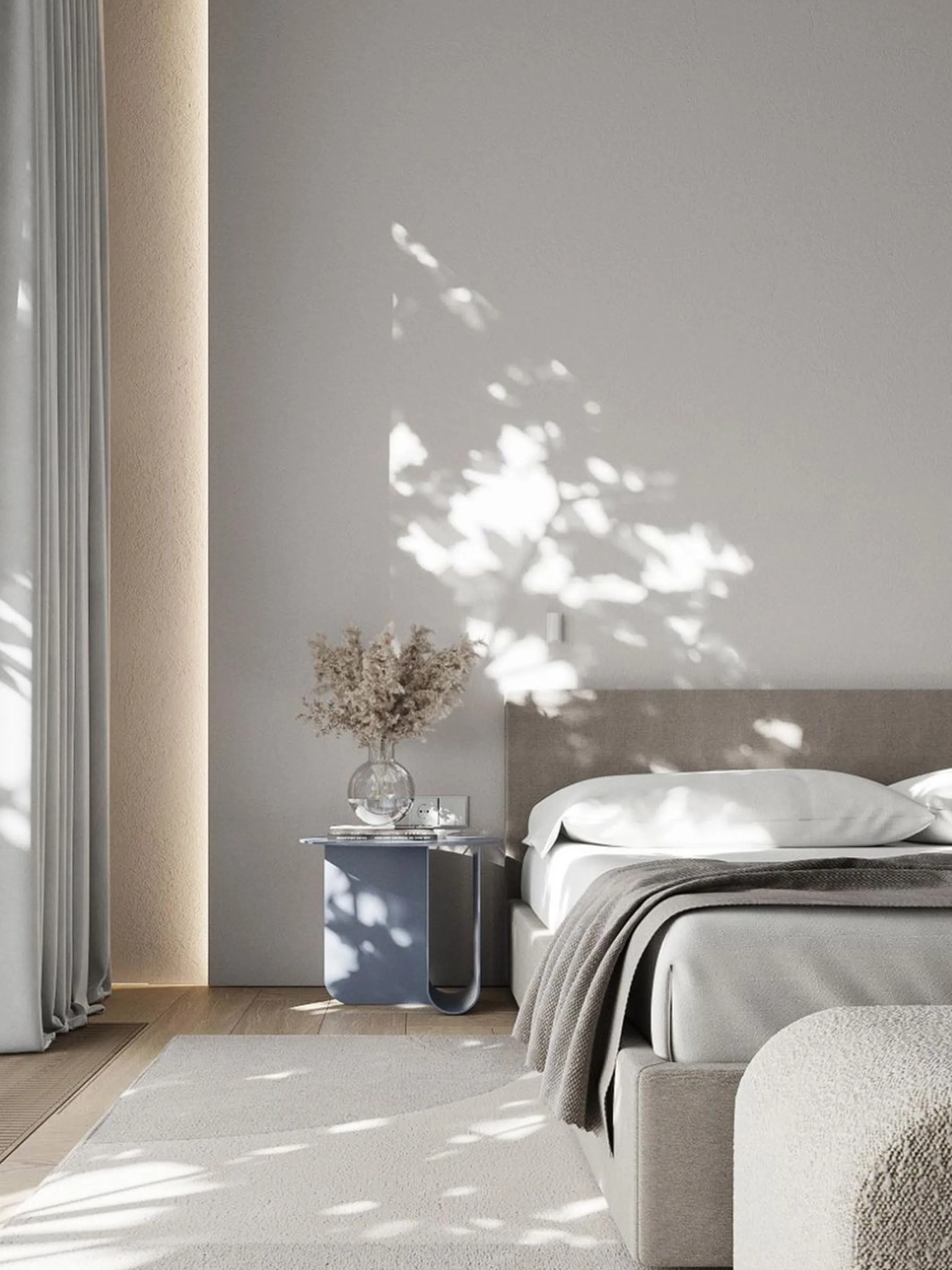 Bedroom with a delicate shadow of outdoor greenery reflecting on the wall.