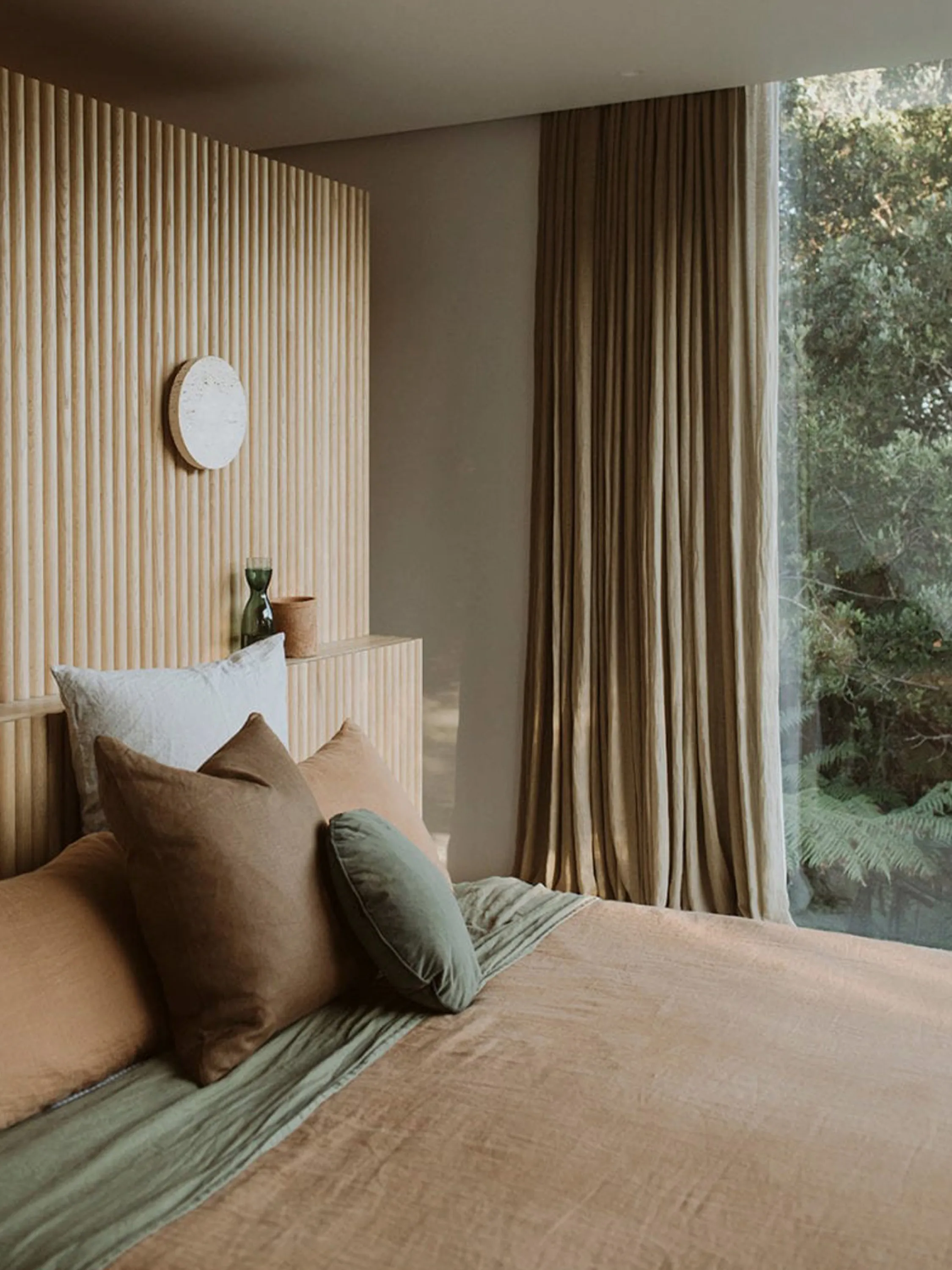 Bedroom with a soft earthy colour palette of greens and tans.